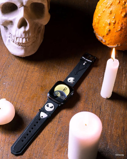 Cureaua Jack Skellington cu Apple Watch, așezată diagonal printre lumânări
